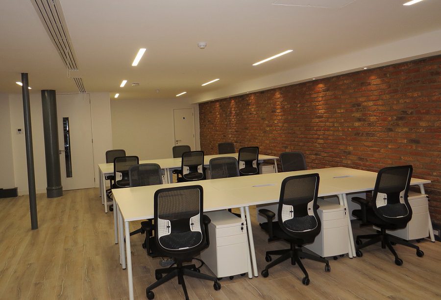 White workbenches in a basement office fit out
