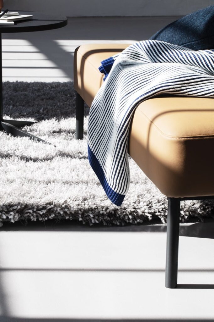 Residential style bench seating or pouffe, in tan leather, in an office setting