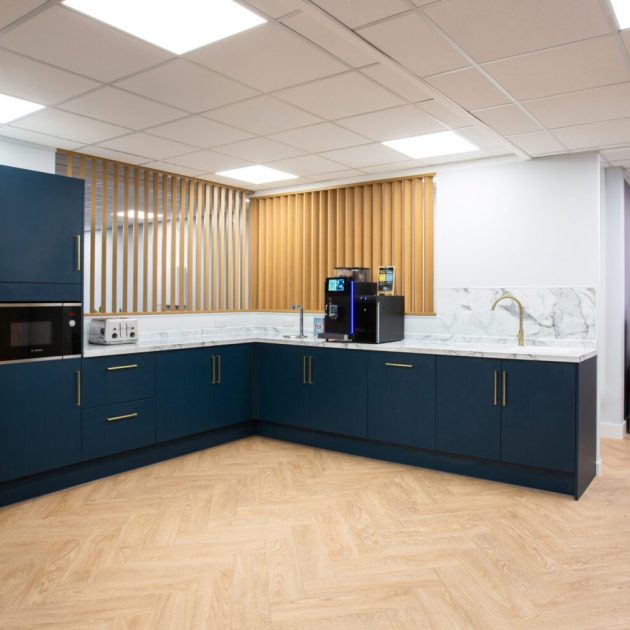 Navy blue office kitchen with panelling feature