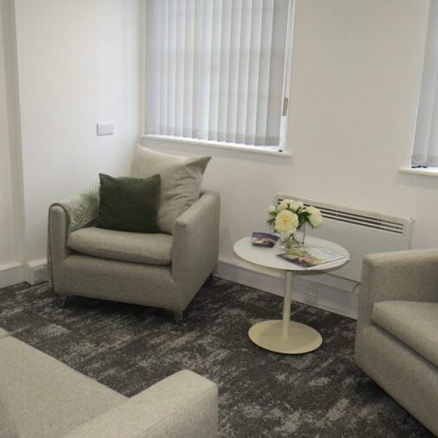 Breakout space with soft seating in grey and dark green accents