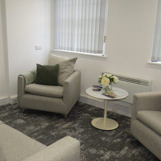 Breakout space with soft seating in grey and dark green accents